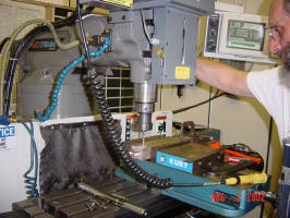 Rob Rowe programs the CNC mill to drill the holes on the rail enclosure.