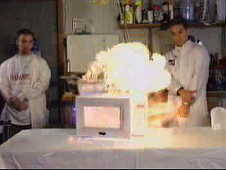 Sam jumps back as the oven explodes in a ball of fire. Click picture to download video.