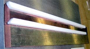 Flat rails with Teflon Spacers on top showing the channel through which the slug will travel.