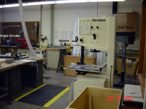 Looking to the right of the workshop from the door; Bandsaw, Drill Press, Jigsaw, Angle Grinder.